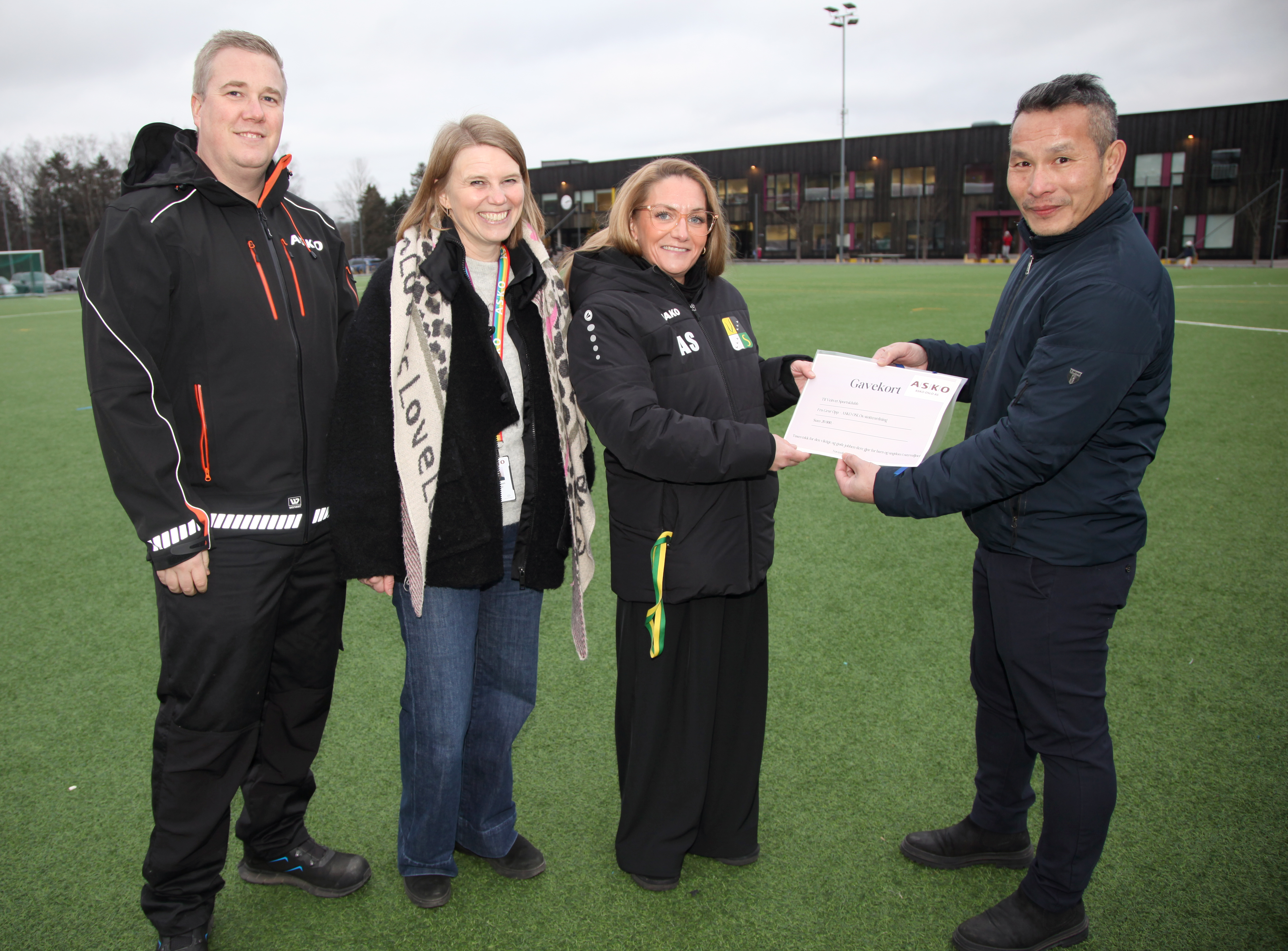 FØRSTE UTDELING: De første 20.000 kronene fra ASKO OSLO gikk til Veitvet SK og deres kafeteria i forbindelse med vinterens futsalturnering i Veitvethallen. Det er lagermedarbeider Luan Nguyen som overrekker sjekken til kioskansvarlig Ane Sjøblom Stensø, mens prosjektleder Christoffer Aaser og HR-leder Ida Elisabeth Rognlid smilende får med seg seansen. 