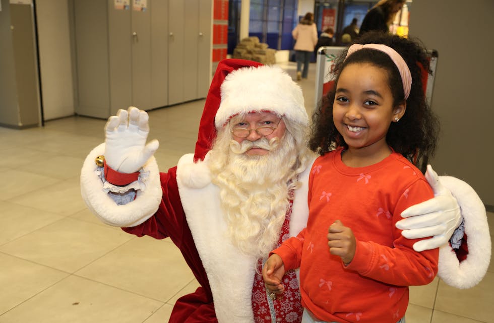 MØTE MED EN KLASSIKER: Smilene satt løst da julenissen tok imot store og små under julefesten på Veitvet senter. (Foto: Tom Evensen)