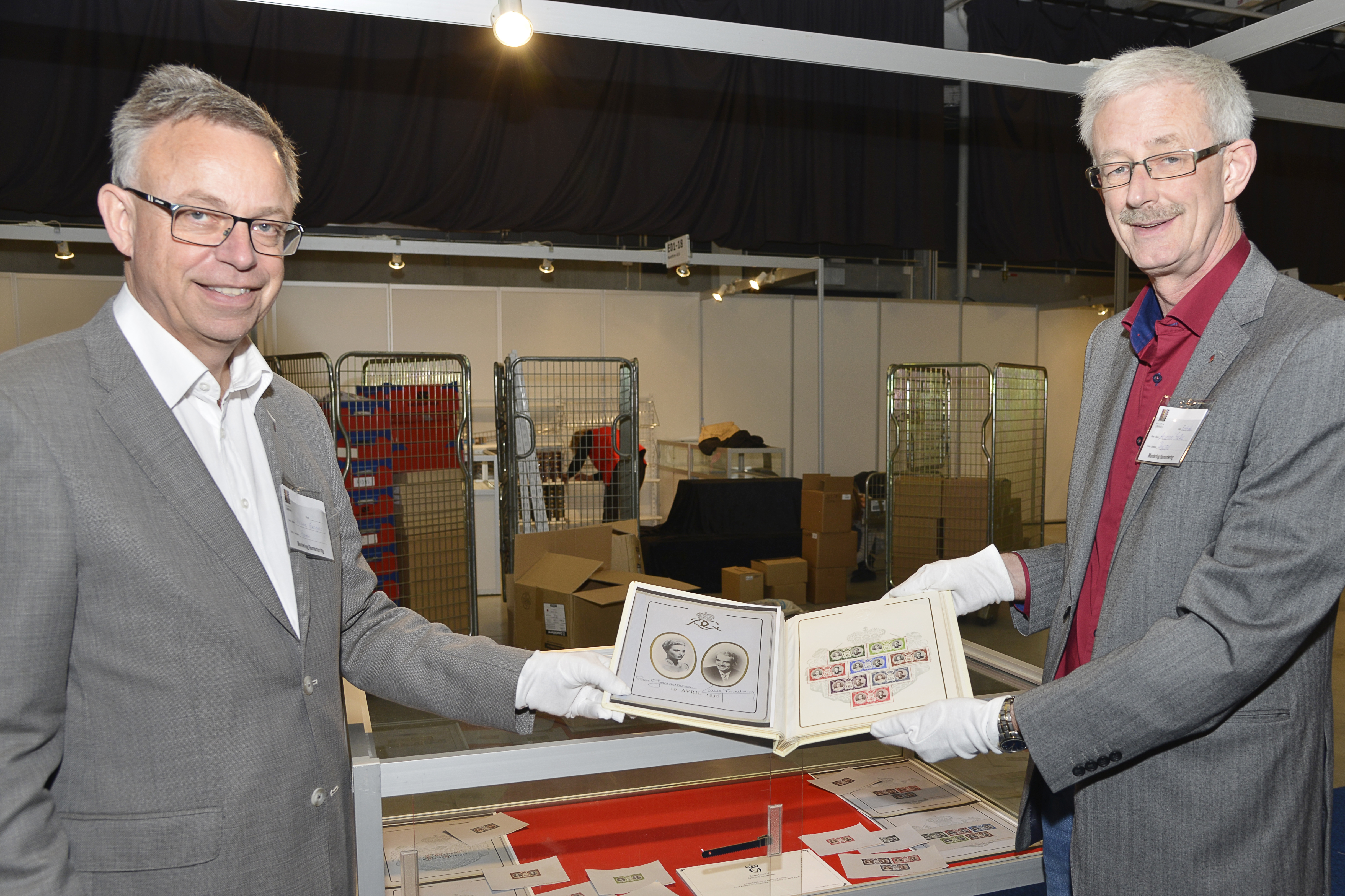 KONGENS SAMLING: Et frimerkealbum til bryllupet mellom Fyrst Rainier fra Monaco og Grace Kelly i april 1956 ble gitt i gave til kong Olav V. Det var blant klenodiene Halvor Fasting (t. v) og Arnfinn Skaale i Postens frimerketjeneste fant da de gikk gjennom kongens frimerkesamling på slottet. Foto: Nils Midtbøen Posten