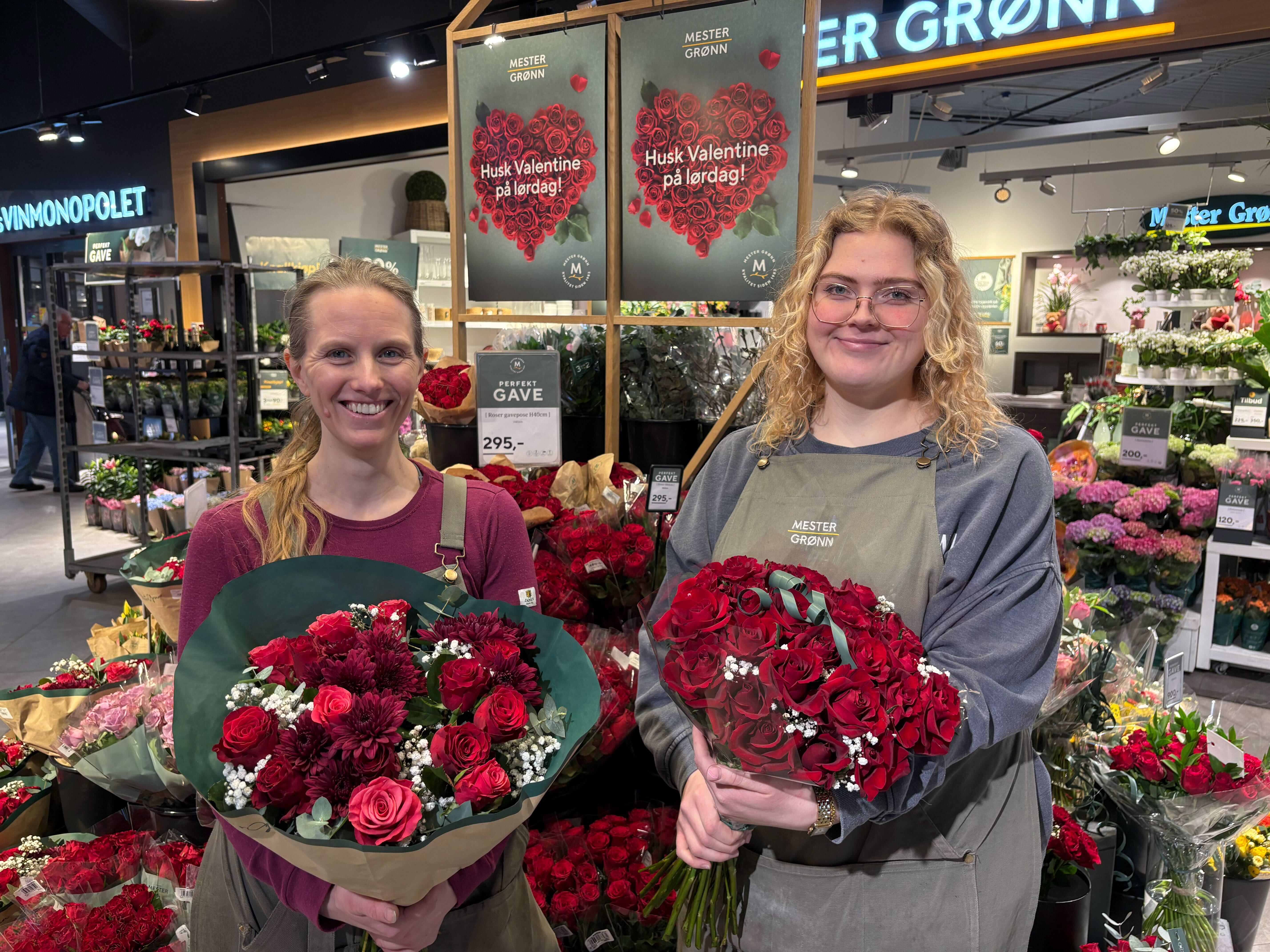 HAV AV ROSER: Butikksjef Kjersti Larsen (t.v.) og nestleder Mathilde Bergset har hatt hektiske uker med både morsdagen som nettopp var og valentinsdagen på lørdag. Her står de foran butikken på Grorud, omgitt av et hav av rosebuketter.