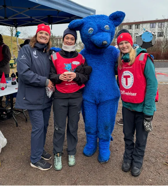 AKTIVITET TROSS SNØMANGEL: Da snøen uteble i desember 2025, ble det likevel arrangert aktivitetsdag på Tveita. Frivillige ungdommer fra Tveita og DNT bidro – og maskoten Turbo var på plass.