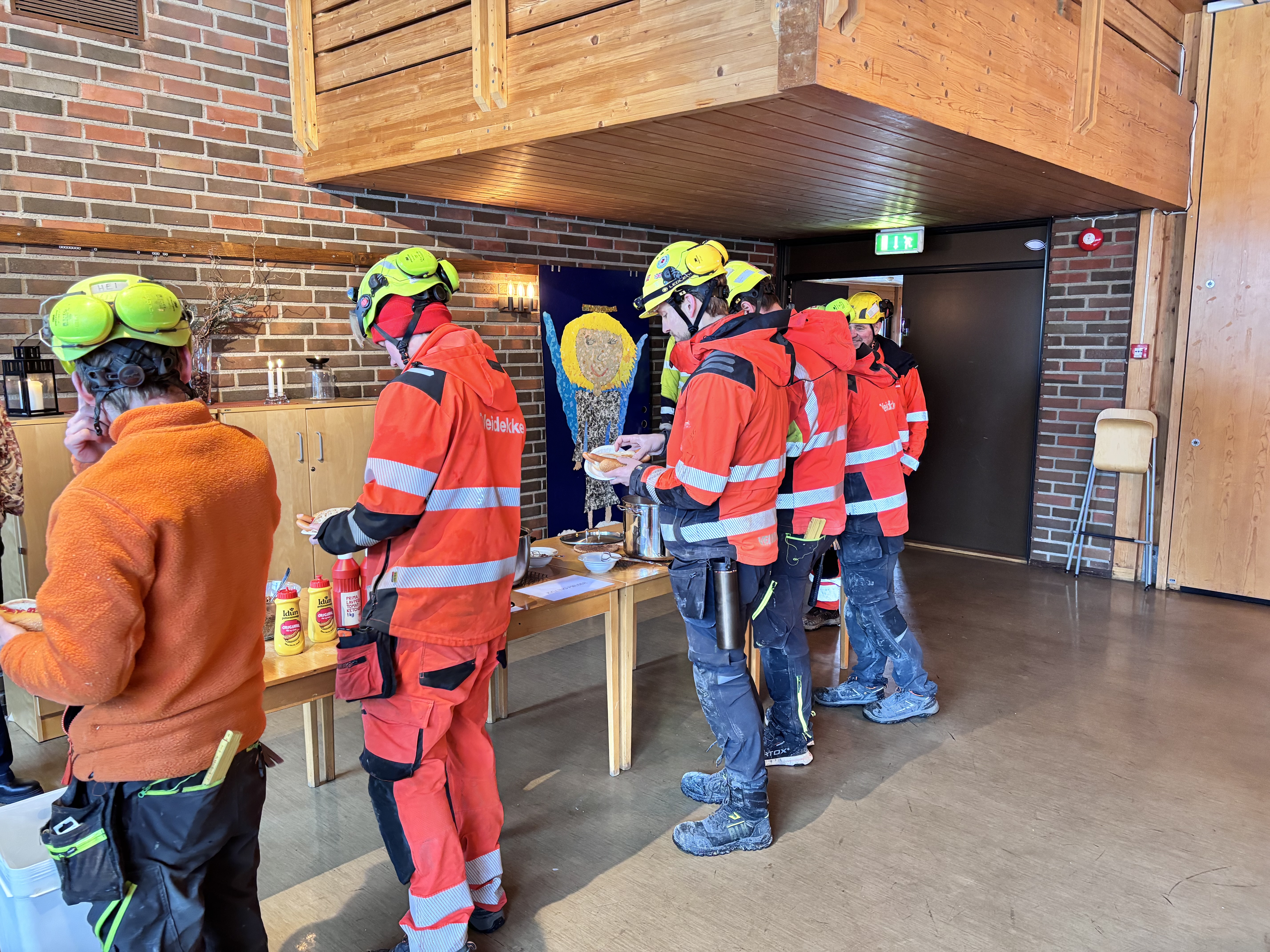 PØLSEKØ: Arbeiderne har nettopp kommet fra arbeid og er klare for et digg måltid med koselig stemning.