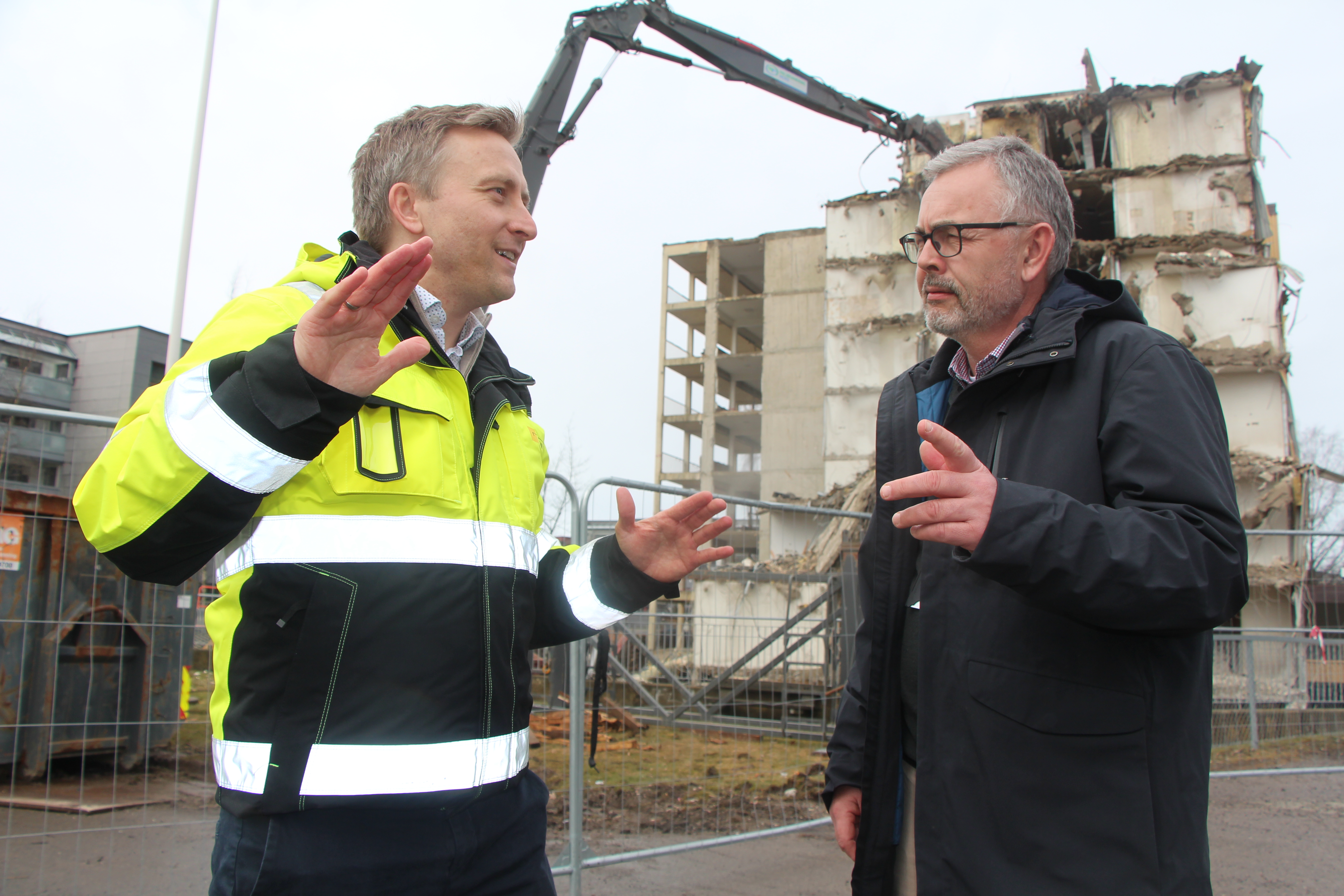 NYTT KAPITTEL: Prosjektleder Espen Hobber Nilsen i Linstow (t.v.) og bydelsdirektør Anders Berg i Bydel Alna følger rivearbeidet tett på den gamle sykehjemstomta på Furuset. Mens maskinene jobber i bakgrunnen, diskuterer de utviklingen som nå er i gang – et arbeid begge mener kan bli starten på et løft for området.