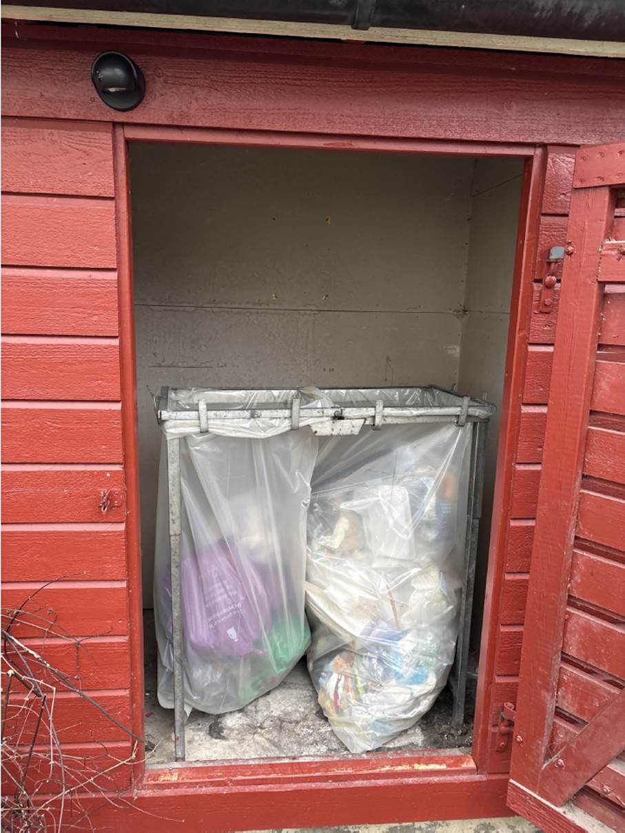 HIT MEN IKKE LENGER: Her, bak søppelkassene i dette skuret på Lindeberg, ble den mistenkte biltyven funnet av politiets hundepatrulje (Foto: politiet).