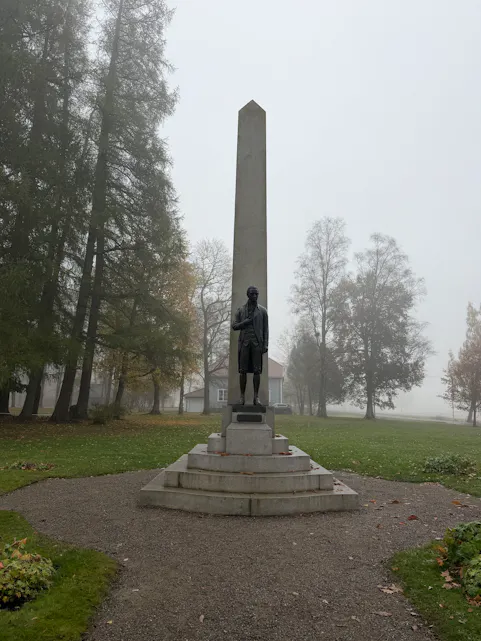 PRIVAT HJEM: Carsten Anker på sokkel foran Eidsvolsbygningen – hans private hjem. Han var både forretningsmann og politiker, og det han han som la til rette for arbeidet med det som ble Grunnloven.
Carsten Ankers hjem er ett av flere hus i denne delen av Eidsvoll som forteller om velstand og soliditet. For oss groruddøler er nabohuset spesielt interessant. Det eies av familien Mathiesen som gjennom firmaet Mathiesen Eidsvold Værk eier betydelige skogområder. Familien eier også Linderud gård i Groruddalen.