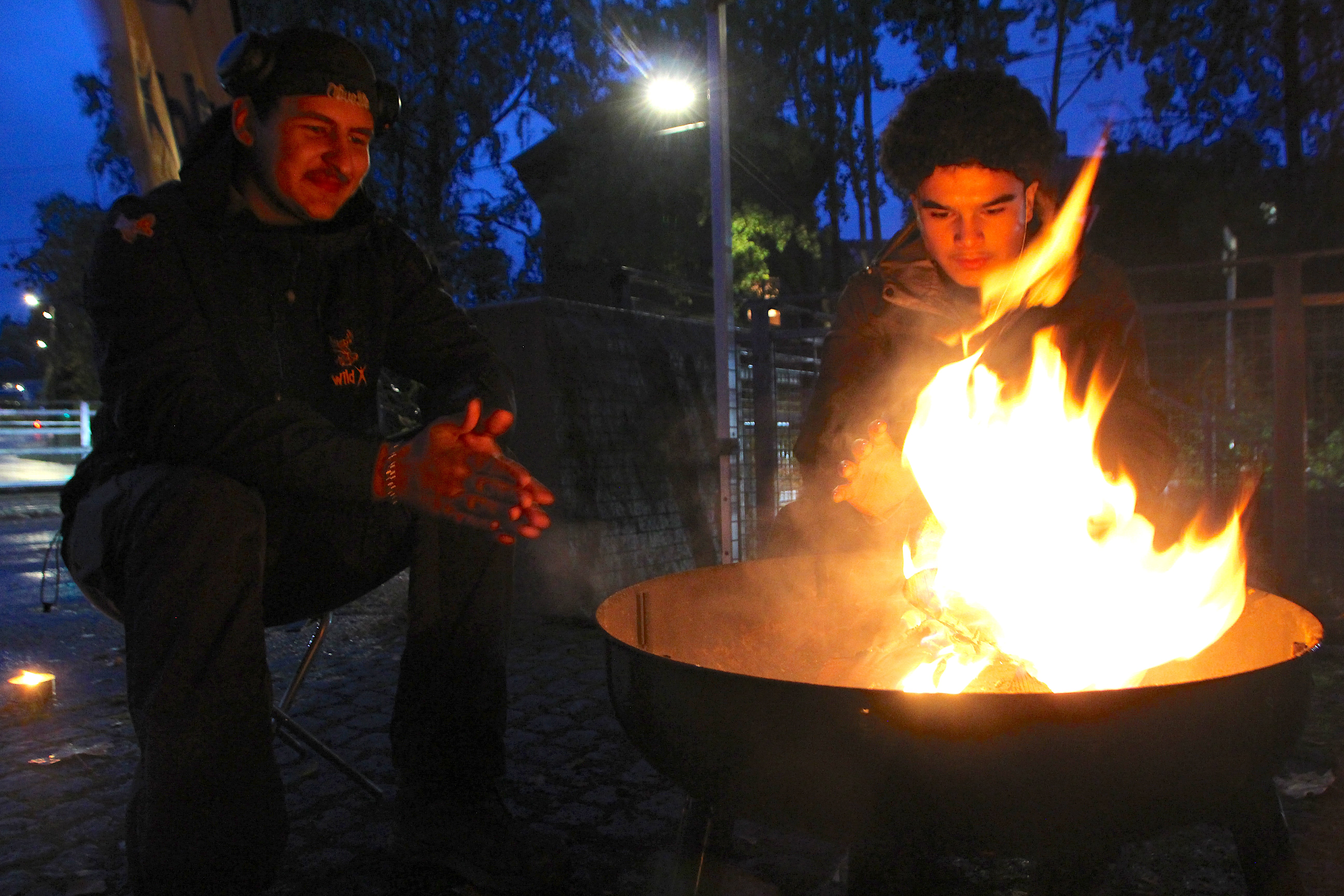 RUTINERTE: Lite varmer bedre enn et skikkelig bål. Mattia (t.v.) og Azad fra WildX satt klare med god stemning og linsesuppe for lysvandrerne. 
